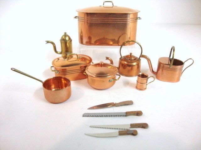 Steak Family Copperware: An assortment of copper and brass kitchen accessories including double boiler 2" L, 1.25" H, and other nicely made items with a selection of cutlery.