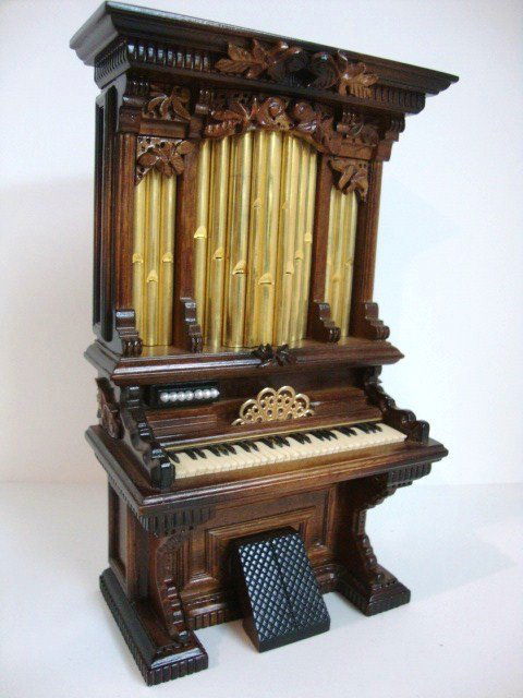 George Becker Organ: A massive fanciful Victorian pump organ 7" H, 4" W with real brass pipes and hand carved details signed and numbered 326 by George Becker. Originally retailed for $440.