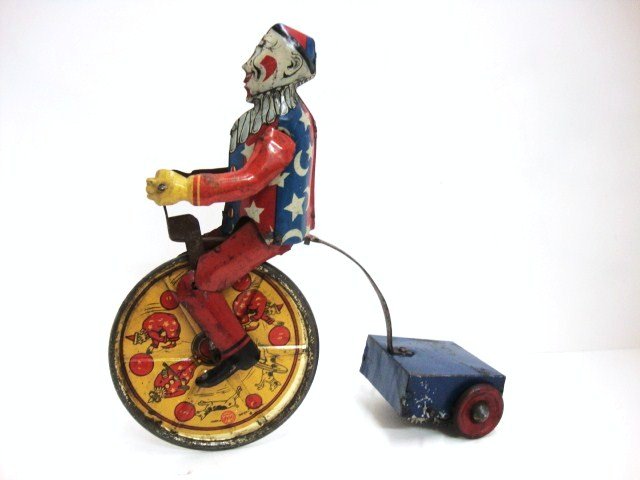 Rare Early Marx Unicycle: Marx Tin Clown on Unicycle wind-up 9" high x 8 1/2" long, with articulated legs. Great Lthos on Wheel