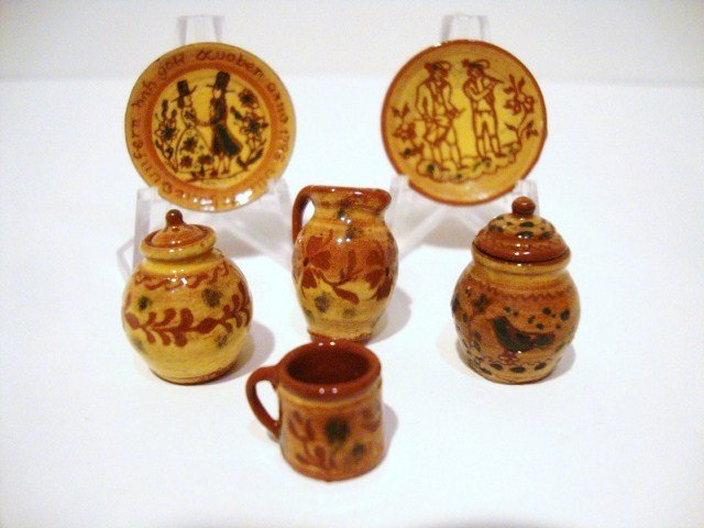 Jane Graber Redware: An assortment of decorated redware by Jane Graber comprising two plates decorated with human figures, two covered jars, a pitcher and a mug. Plates 1" diameter.