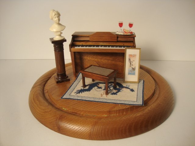 Cheese Dome Display: A music room under glass featuring a nicely constructed artisan piano (glued in place) with bench, a very fine oriental petitpoint rug, a Marjorie Adams Japanese watercolor and a bust on a pedestal. A