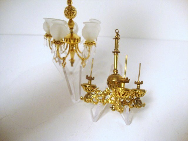 Ellen Krucker Blauer Chandeliers: Two brass chandeliers: one electrified five arm Regency and a non-working gasolier with frosted globes. 2.5" H.