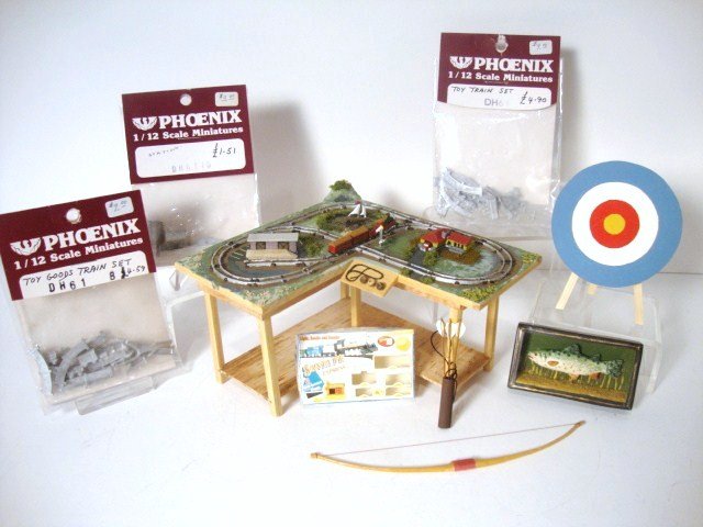 Boy's Toys: A detailed train layout on a table by Scott Nielson 3" H, 5.25" L and W, and from the Singing Tree, an archery set, mounted fish and unpainted train set by Phoenix Crafts.