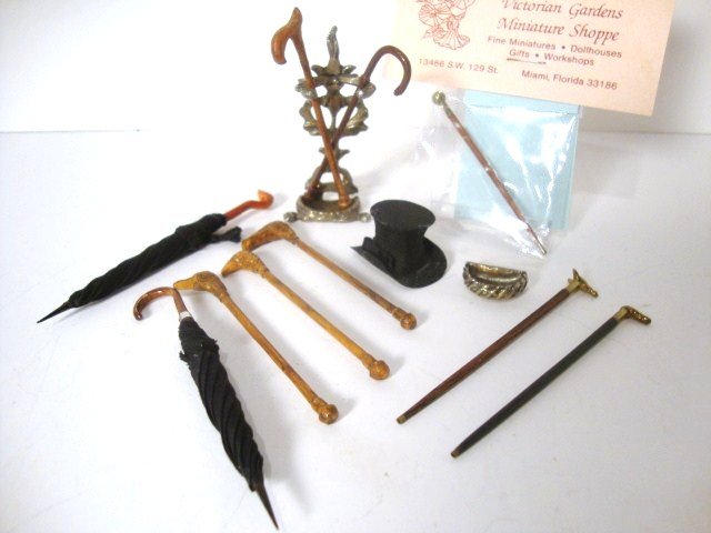 Don't Forget Your Brolly: Two handsome furled umbrellas from the Singing Tree 3.5" L, a painted metal umbrella stand, an assortment of walking sticks and a gentleman's top hat.