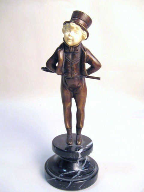 Georges Omerth Bronze & Ivory Figure: A Cast Bronze and Carved ivory figure of a young gentleman with hat and cane on a marble base. Circa 1910. 8 1/2" tall. Signed " Omerth"