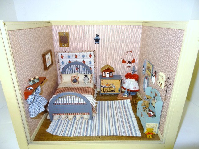 Child's Country Bedroom: Small roombox furnished as a little girl's bedroom with a rag doll theme, featuring a nicely dressed bed, handwoven rug, cute painted furniture, dresses and decorative items. 11" H, 13" W, 11" D. Ex-J