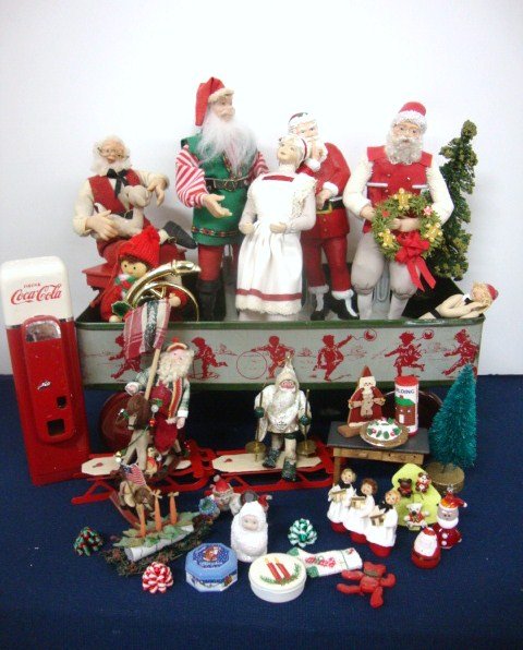 Artist and Contemporary Santa Scene: Wonderful group of Santa Figures, no markings, together with many small Holiday figures, Rocking Santa, Snowmen, Snow Baby, and much more. Santas are riding on an early lithograph wagon. Merry Christm