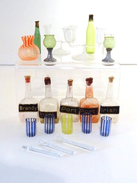 Antique Bottles and Glassware: Five labeled liquor bottles approx. 1.75" H, two glass candelabra, two goblets with metal stems and assorted beakers, bottles, vases and spoons.