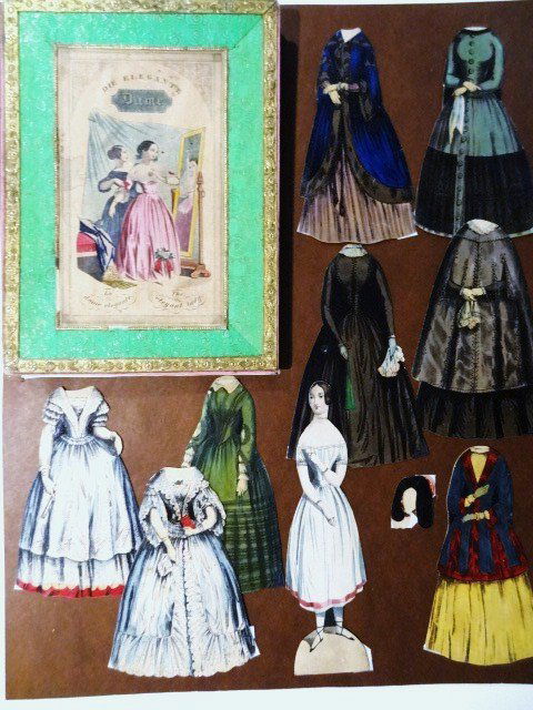 Die Elegant Dame F&B: Antique paper doll: Die Elegant Dame, box lid, doll 8.5" H with neck mends, eight dresses and one headpiece, 1840's.
