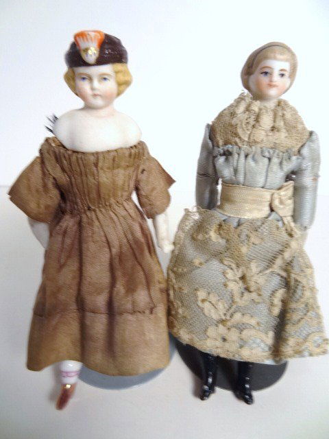 Pair of Parian Head Ladies: Two dollhouse Parian head ladies: a smiling Simon and Halbig girl 4.75" H with café au lait hair and black head band, blue eyes, on cloth body with Parian lower arms and black boots, original homemad