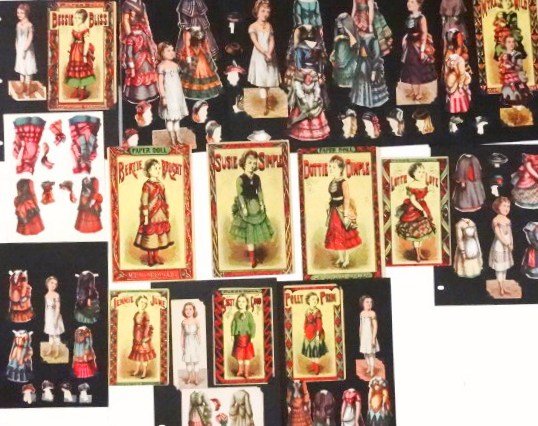 Nine McLoughlin Sets with /Folders: Polly Prim 5.5" with four dresses and original folder; Girty Good 6" uncut with two uncut dresses and original folder; Myra Mild 6.5" with three dresses, two hats, original folder; Bessie Bliss 6.5" w