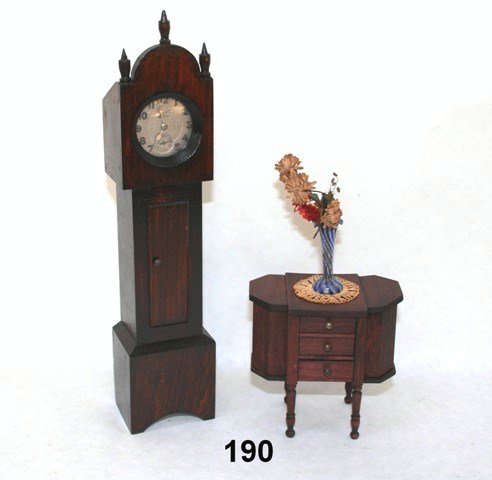 Homemade Watchholder and German Sewing Table: A vintage homemade grandfather clock holding an American Radiolite pocket watch (does not seem to work) 10" H, a German red stain Martha Washington sewing table 3.5" H and W, and a vase of flowers.