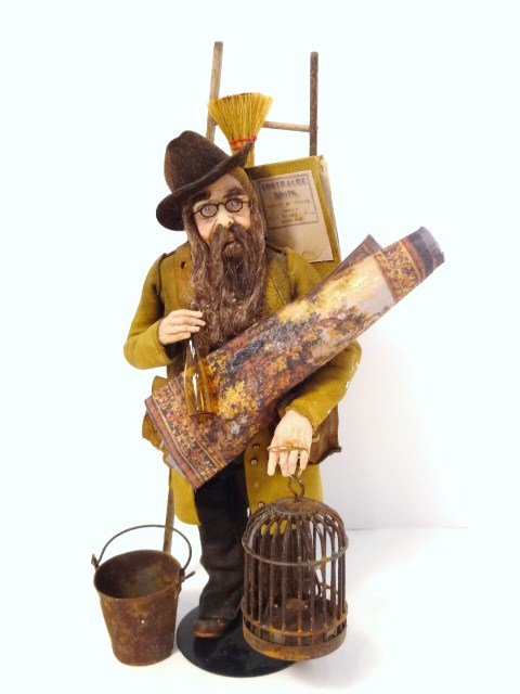 Marcia Backstrom Travelling Man: We're not sure what he's up to, but he's clad in a weathered leather coat and fedora, carrying an odd assortment of things including an apple-picking ladder, basket with pillow, birdcage, tin bucket, 