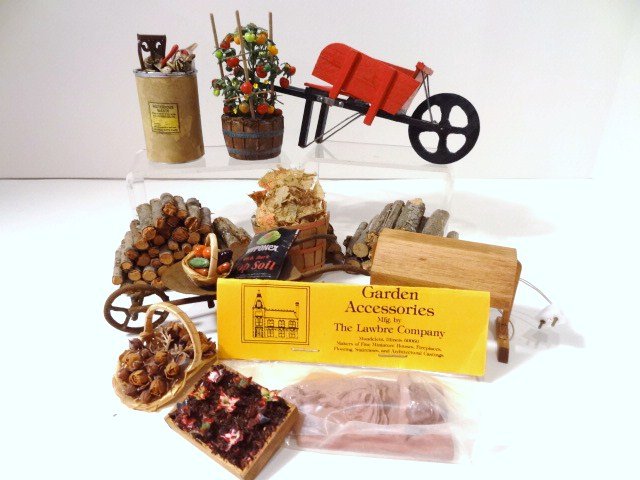 Behind the Garden Shed: Assortment of items for the working garden comprising a delightful tomato plant by Marcy Jaffe 3" H, two wheelbarrows, trash can, flat of seedlings under a grow-light and tools, etc.