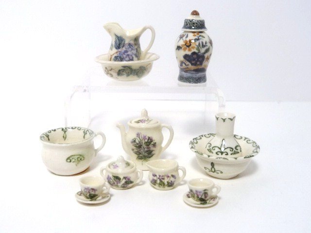 Jean Tag Victorian Tea Set and Toilettes: A Victorian tea service for two with grape cluster design, also a matching pitcher and bowl 1" H, a colonial 3-piece toilette set with classical green design and a polychrome covered jar, all by Jean 