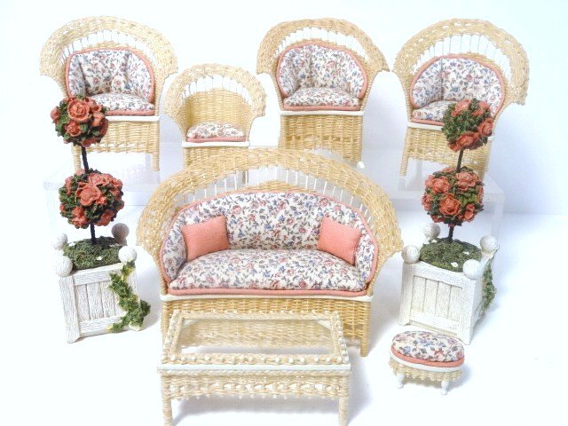Barbara Main Wicker Furniture: Inviting little suite of upholstered wicker furniture comprising a settee 3.25" H, 5" L, two chairs, a rocker, glass-topped table, child's chair and footstool. Terribly sweet. With a floral rug and tw