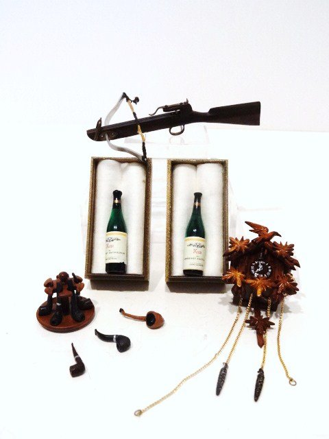 Artisan Cross-Bow: Wonderfully detailed rosewood crossbow 3 and 1/8" L (bowstring frayed), a mahogany pipe rack by Tom Warner with seven pipes 3/4" H and a pretty spectacular hand-carved cuckoo clock by Linda Master. Al