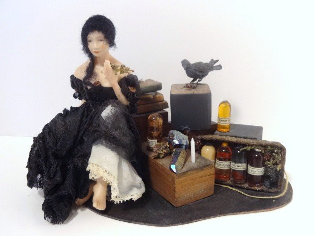 Shirley Whitworth Potion Peddler: One of a kind spooky lady in tattered black clothing seated amidst her vile potions, herbs and powerful gems overseen by a sinister black crow. Moody and mystical. One broken ankle poorly repaired. 4.