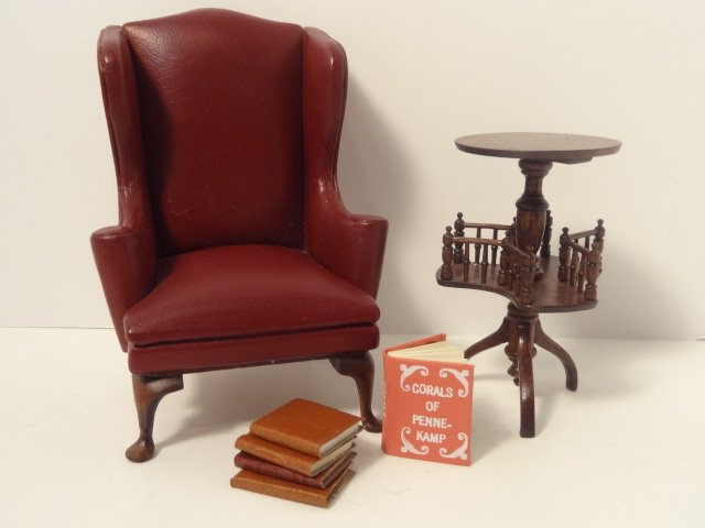 Gerald Crawford Book Table: A Victorian mahogany tripod table with galleried book shelf by Gerald Crawford 2 5/8" H, and a leather upholstered wing chair signed RSJ '79 4" H. With an assortment of faux books and a bound copy of 