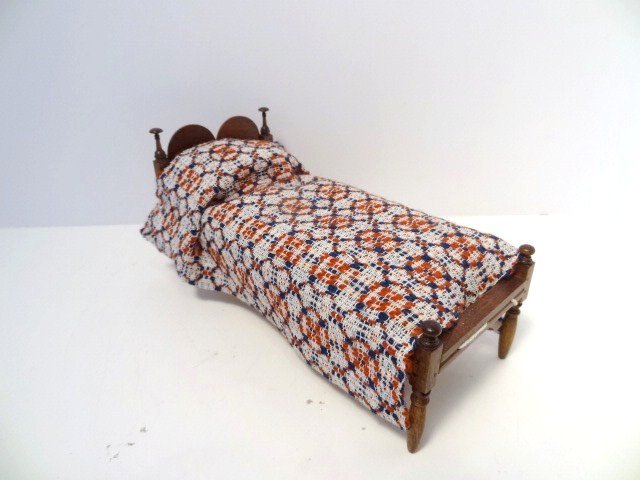 Roger Gutheil Low-post Bed: Charming little low-post rope bed with mushroom finials, double headstone headboard and draped with a lovely woven coverlet by Martha Dooling. 2.78" H, 6" L, 2.5" W.