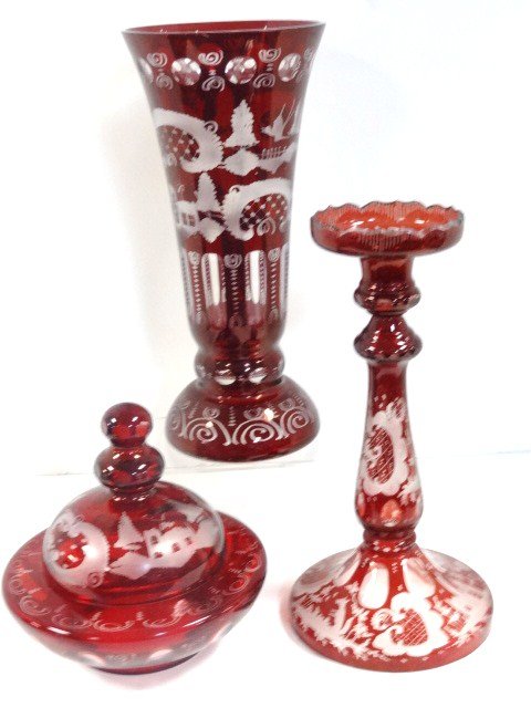 Bohemian Ruby Glass Vases and Lidded Dish: Three pieces of Bohemian ruby glass, cut to clear, candlestick w/animals on base, covered dish, large vase w/outdoor scene, 12 in. tallest