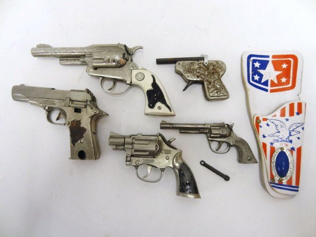 Five Vintage Toy Guns and Holster: A lot of 5 toy guns and a holster, a Hubley Texan Jr cap gun having a white plastic handle with a steer head in black on it, Hubley Automatic pistol, Automatic (unmarked) cap gun tin w/double barrel,