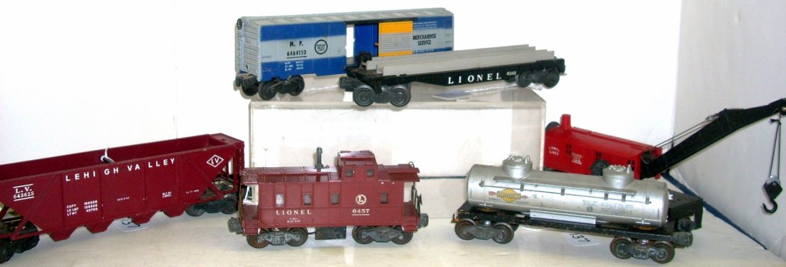 Six Lionel O Gauge Freight Cars: Lot of 6 vintage Lionel freight cars, 6560 crane, 6436 hopper, 6464-150 box car, 6465 tanker, 6262 flat (no load), & 6457 caboose