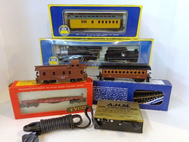 HO Mixed Models Train Six Cars, Track, Transformer: Six mixed trains pieces along with track & transformer, AHM Usra Switcher & tender, Tyco (Mantua) old time coach, Tyco PA flatcar, AHM old time baggage car, old time caboose, AHM track set in box (11 