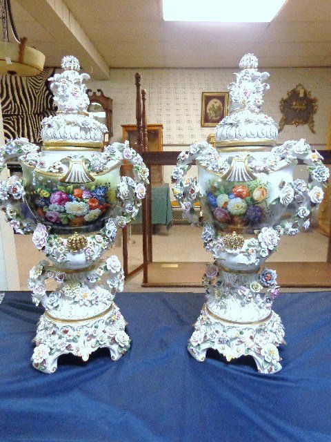 Pair Monumental Capodimonte Style Urns: Matched pair of incredible decorative lidded urns w/handles, exuberant applied ceramic floral decoration & gold paint, beautiful hand painted floral arrangement in panels both front & back, signed ind