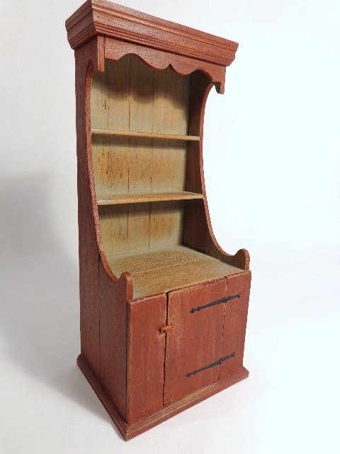 William Robertson Cupboard: A country cupboard with weathered red paint, very fine strap hinges, dated 1985. One of only three examples ever made. 6.75" H, 2 and 7/8" W. Cabinet from the kitchen of Twin Manors. Made either 3 or