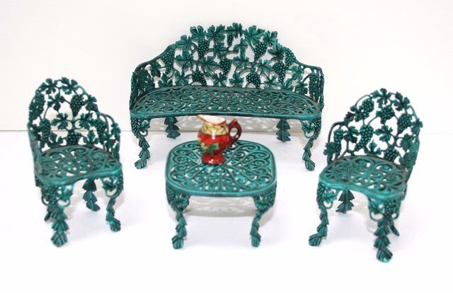 Victorian Garden Furniture: Suanne Russo's delicately modeled cast metal garden furniture with grapevine motif and verdigris finish comprising a settee 3" H, 4" L, a table and two matching chairs. Very minor paint loss.