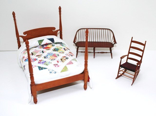 Cherry Bed and Artisan Seating: An unsigned cherry four-poster bed 5.75" H, 6.5" L, 5" W dressed in pineapple quilt, a Windsor settee by William Clinger and a Shaker rocker by George Pennell.