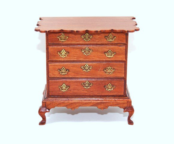 Walter Schutter Chippendale Chest: Stunning cherry four-drawer chest with elaborately scalloped top and scalloped apron, delicate brass drawer pulls and escutcheons. 3" H and W. Small scratch on one door barely visible in person.