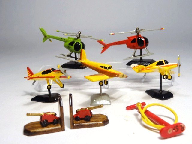 Robert Street Aerial Toys: Three airplanes and two helicopters on stands approx. 2" L, a pair of cannon bookends and a bicycle pump, all by Robert Street.