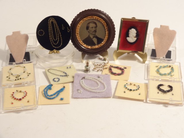 Necklaces To Go: Assortment of eleven miniature necklaces, pocket watch, cameo, perfume bottle, and an antique tinted ambrotype in round frame 1.75" diameter.