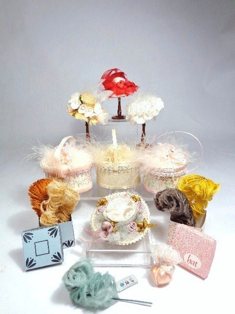 Hats and Hatboxes: Three fancy hatboxes with handles by Pat Stevens (empty), assorted hats by Peggy and others, milliner's plumage and three hat stands 2.25" H.