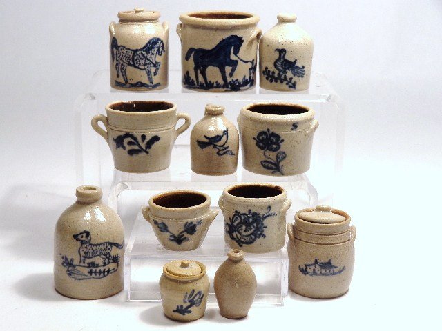 Carolyn Curran Stoneware Jugs and Crocks: A dozen decorated stoneware jugs and crocks by Carolyn Nygren Curran. Tallest jug 1.25" H. Two jugs missing handles.