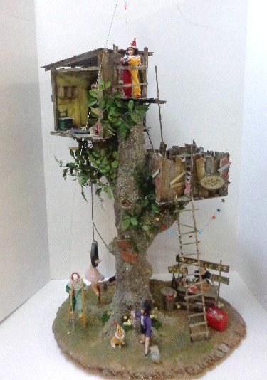 Treehouse Carnival: A delightful open diorama featuring a two-level treehouse set amid a children's circus or carnival. Incredible detail and the five dolls are wonderfully costumed. 36" H (top of kite), 20" W, 11" D. I