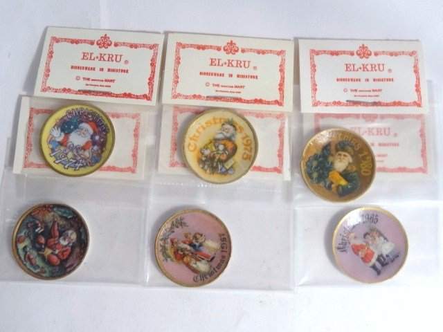 El-Kru Christmas Plates: Six Ellen Krucker Christmas plates from different years between 1974 and 1985, 1" diameter, in original packaging.