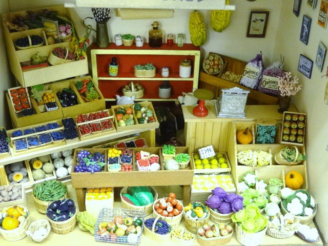 The Fruit Shed Roombox: A roombox furnished as "The Fruit Shed", lavishly filled with artisan fruits and vegetables with baskets of luscious-looking berries, eggplants, apples, grapes, oranges, cauliflower, bags of onion set