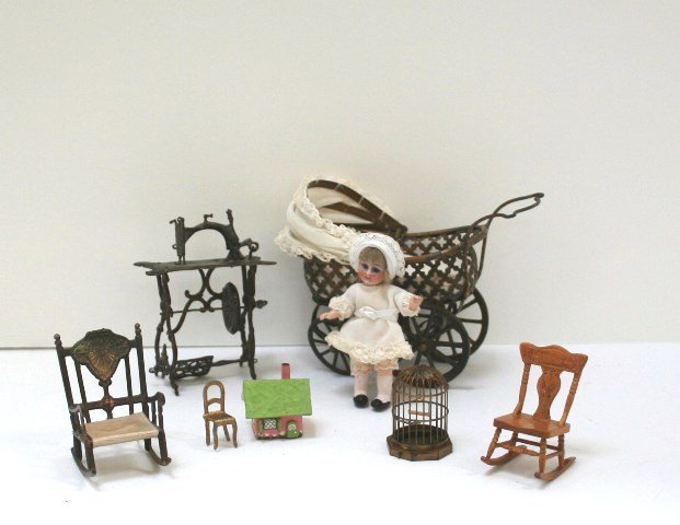 Antique Sewing Machine and Carriage: A delicate treadle sewing machine with asphaltum finish 3.25" H (missing treadle connector)with an unusual vintage baby carriage with painted gilt finish and newer upholstery (one wheel mount needs to