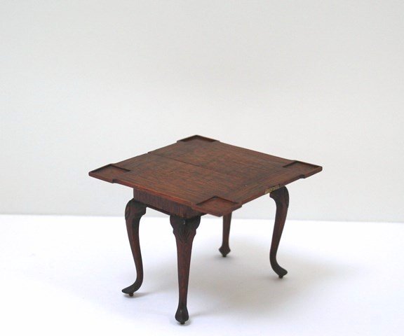 Julian Biggers Game Table: Beautifully grained mahogany was used to construct this elegant Queen Anne games table with recessed corner wells, very fine gadrooned apron and hand-carved knees. The top swivels and the hinged secti