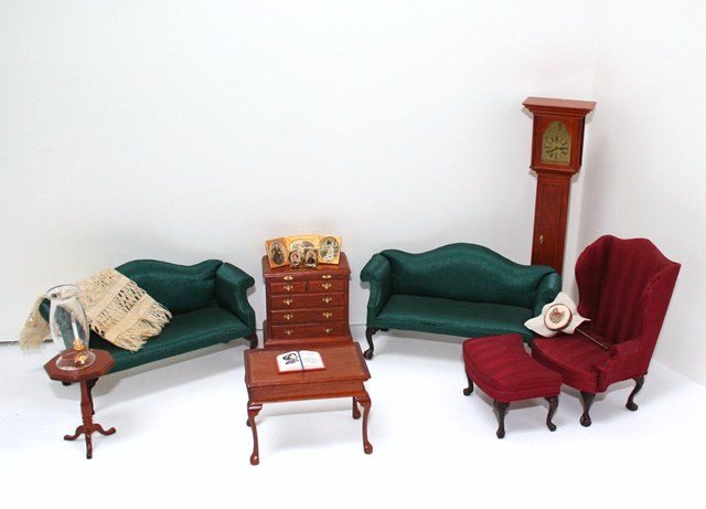 Early American Furniture: An assortment of commercial furniture comprising a matched pair of camelback loveseats upholstered in green silk 3" H, 5.75" L, an upholstered wing chair with matching footstool, and four pieces of fa