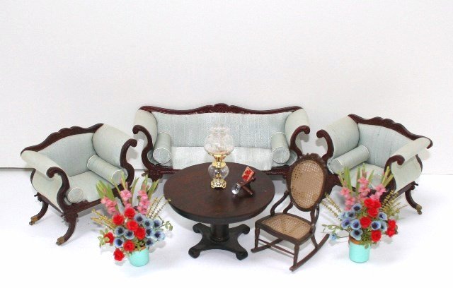 Classical Parlor Group: A matched set of commercial furnishings with sofa 3.25" H, 6.25" L, two matching armchairs, a handsome Empire parlor table by Verl Kraeger, a rocking chair and two colorful flower arrangements.