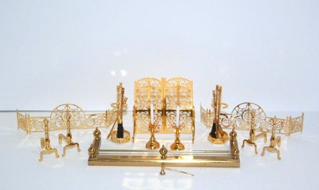 Clare Bell Brass Fireplace Items: An assortment of fireplace accessories, mostly by Clare Bell Brass including a fire screen 2" H, three fenders, two pairs of andirons, two sets of fireplace tools and a pair of candlesticks with snuff