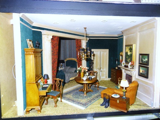 Whitledge Gentleman's Room: A masculine bedroom roombox featuring an equestrian theme with hunting pictures and riding boots in the foreground, tufted leather chair and ottoman, French bed in its own alcove, a hound peeking in t