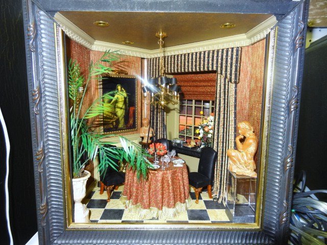 Whitledge Dining Room: An intimate dining space featuring draped table surrounded by gilt chairs and laid with Christopher Whitford porcelain plates, handsome two-tiered chandelier with shades, potted plants, elegant sidebo