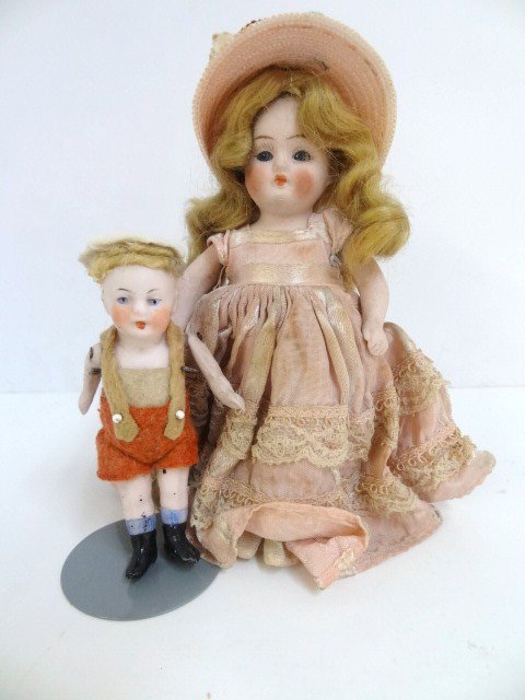 Two German Dolls: Two German dolls, a 5 in. w/glass blue eyes, blonde mohair wig, straw hat & original silk dress, marked 500-13, other is 3 1/2 in. bisque boy w/felt clothes, painted eyes