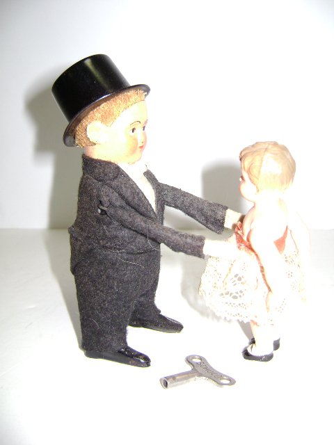 Schuco Dancer Boy in Tuxedo with Girl: Schuco Germany, clockwork driven boy dressed in black tuxedo with tin top hat, white shirt and bowtie, celluloid girl with lace dress, 5.25"H, boy spins while lifting girl