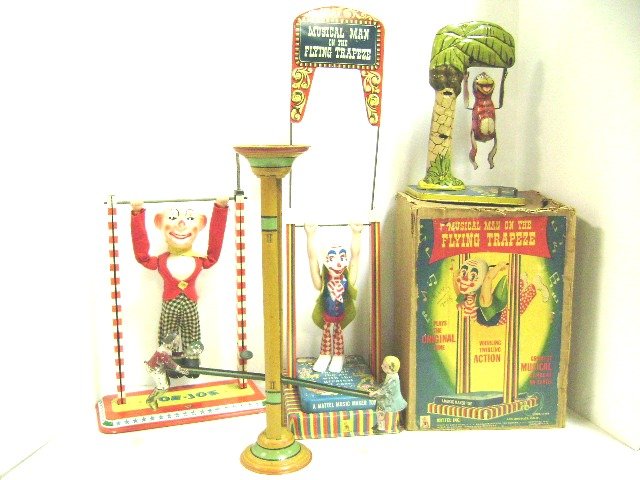 Three Tin Trapeze Toys and Seesaw: Mattel Musical Man on The Flying Trapeze in O.B., Ohio Art Toe Joe, Unique Art Bombo the Monkey, early painted tin gravity seesaw toy with paint loss, tallest 22"